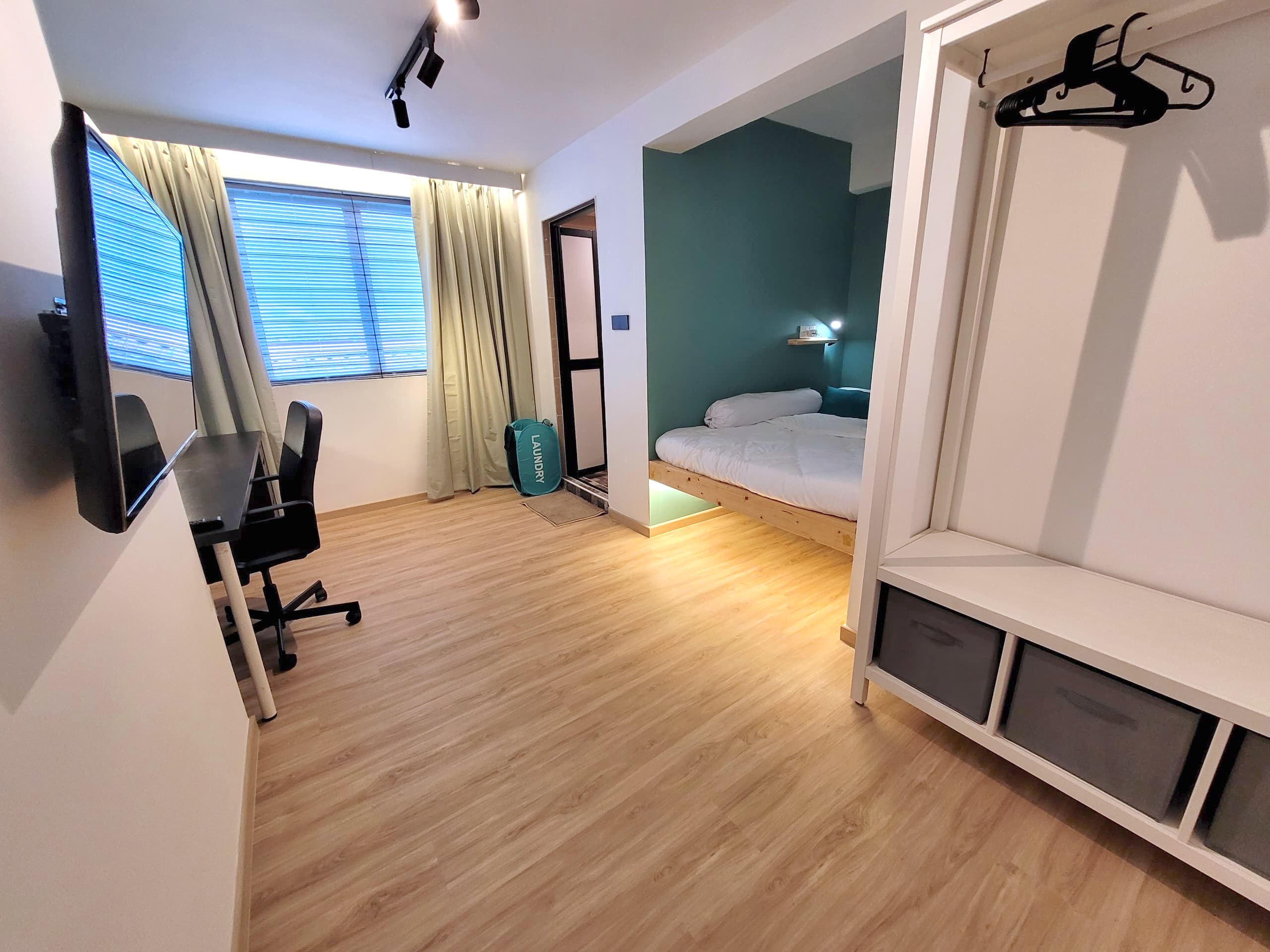 A spacious private room with a large bed and workstation