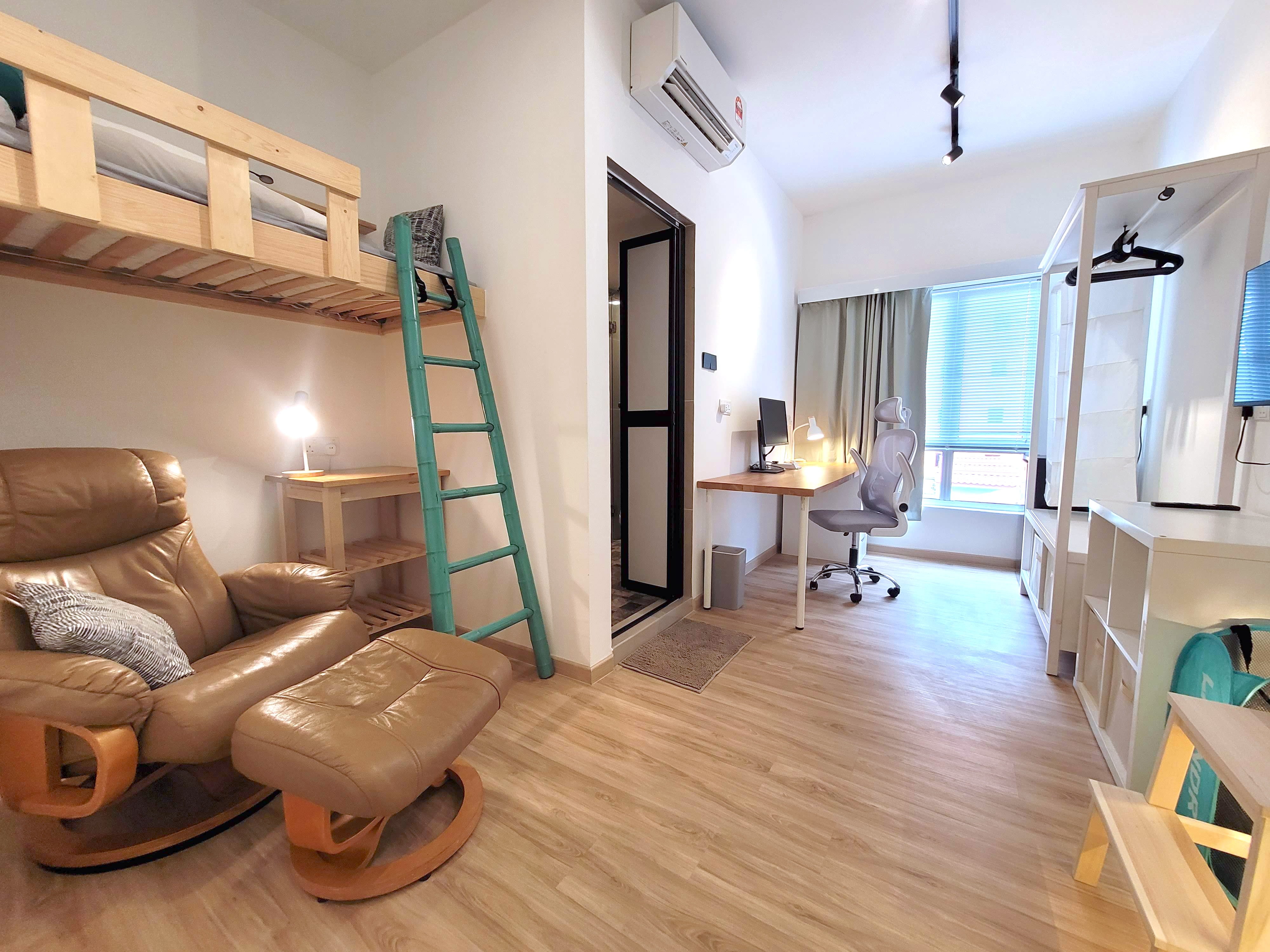 A loft living space with lounge chair, raised bed and workstation