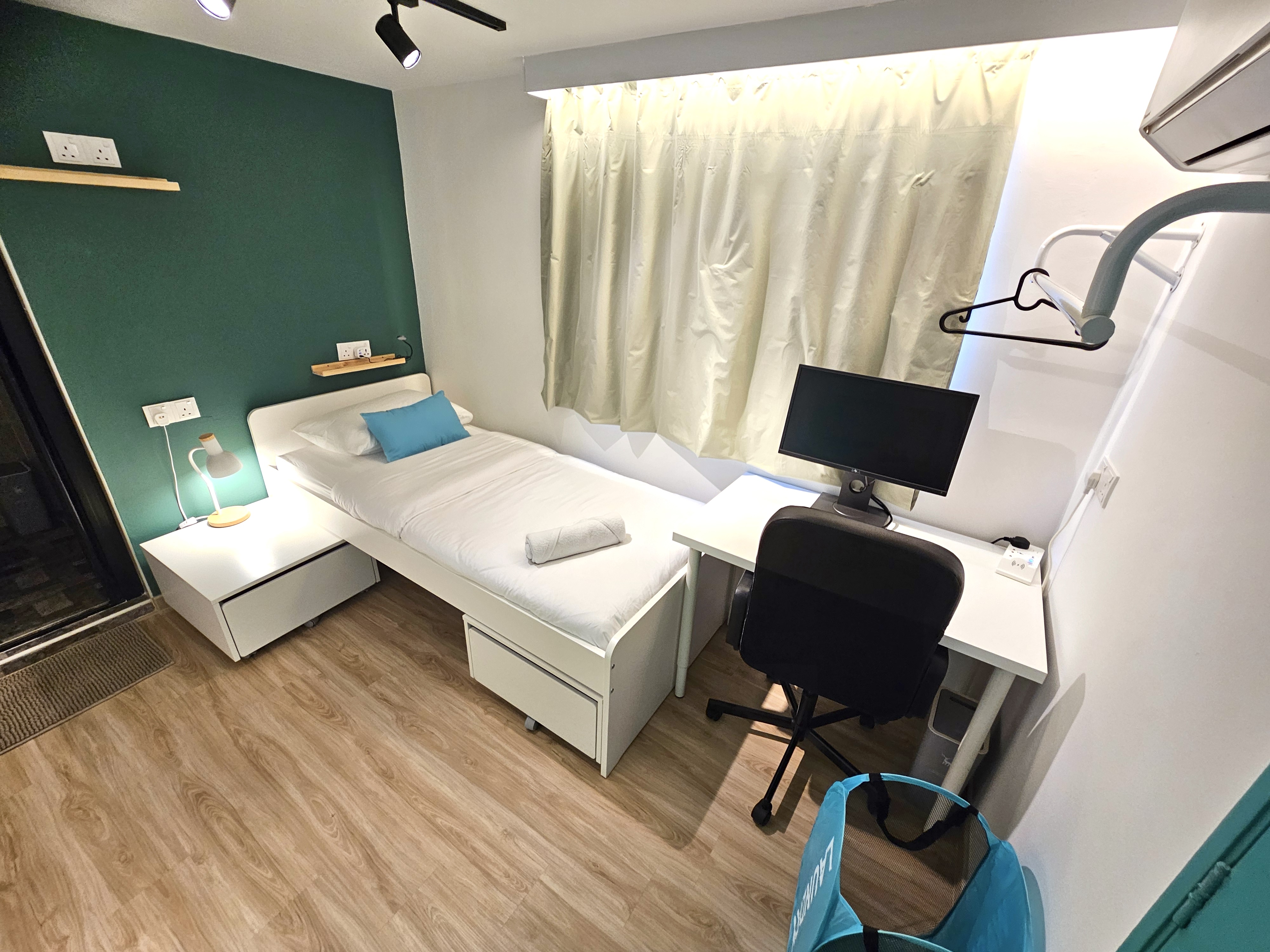 A compact private single room with monitor and desk